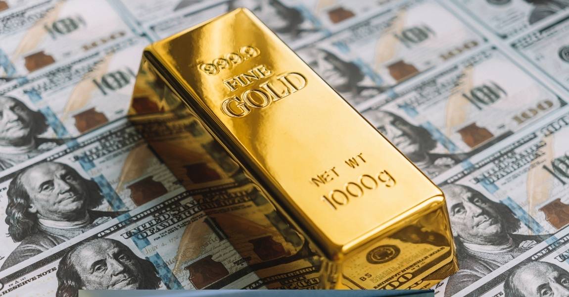 gold bar on top of dollar bills