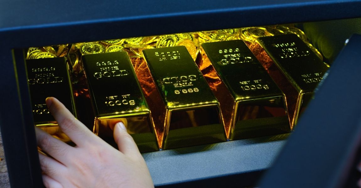 gold bars being put into a storage box