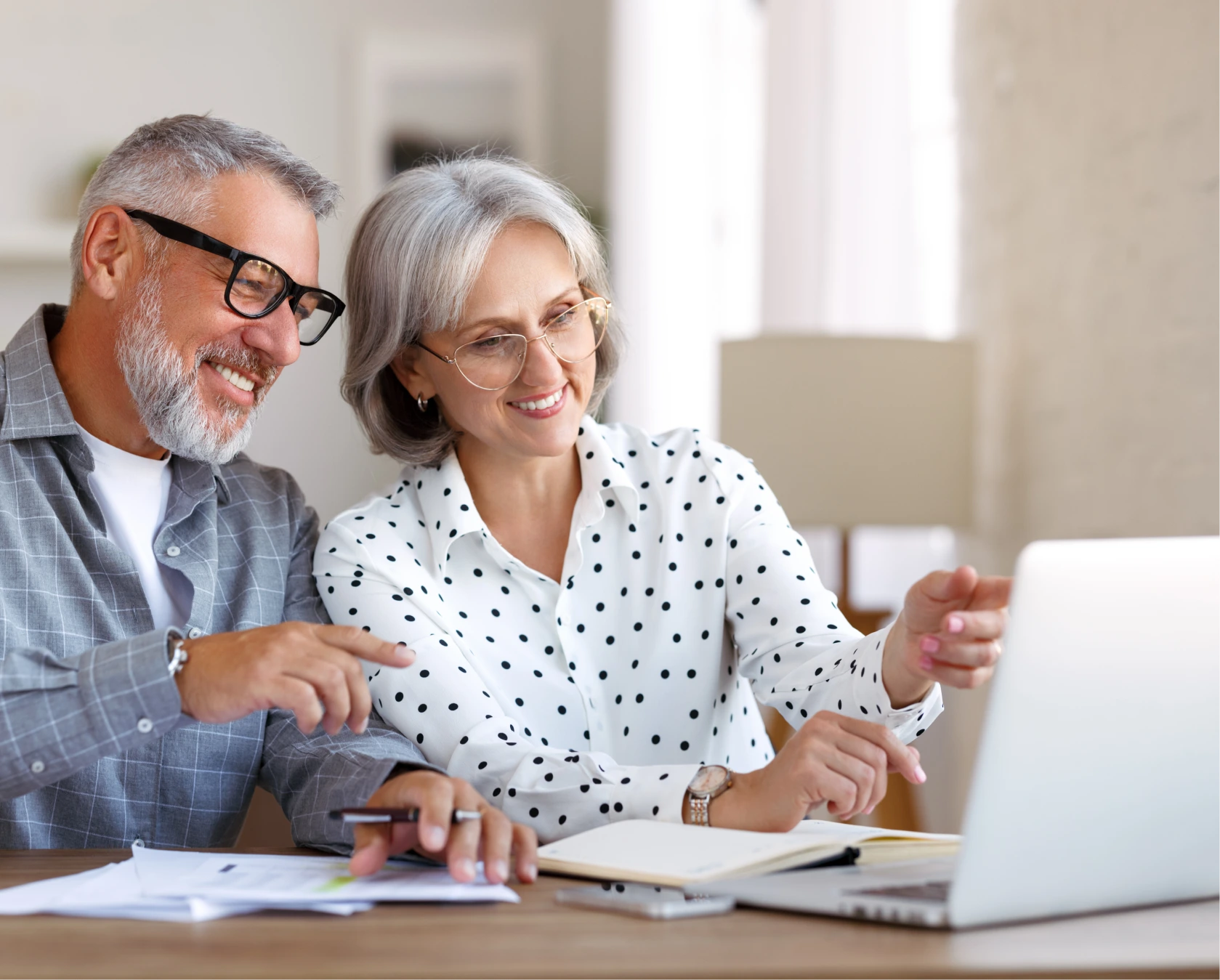 Senior family couple studying online together, retired man and woman looking at laptop and discussing something
