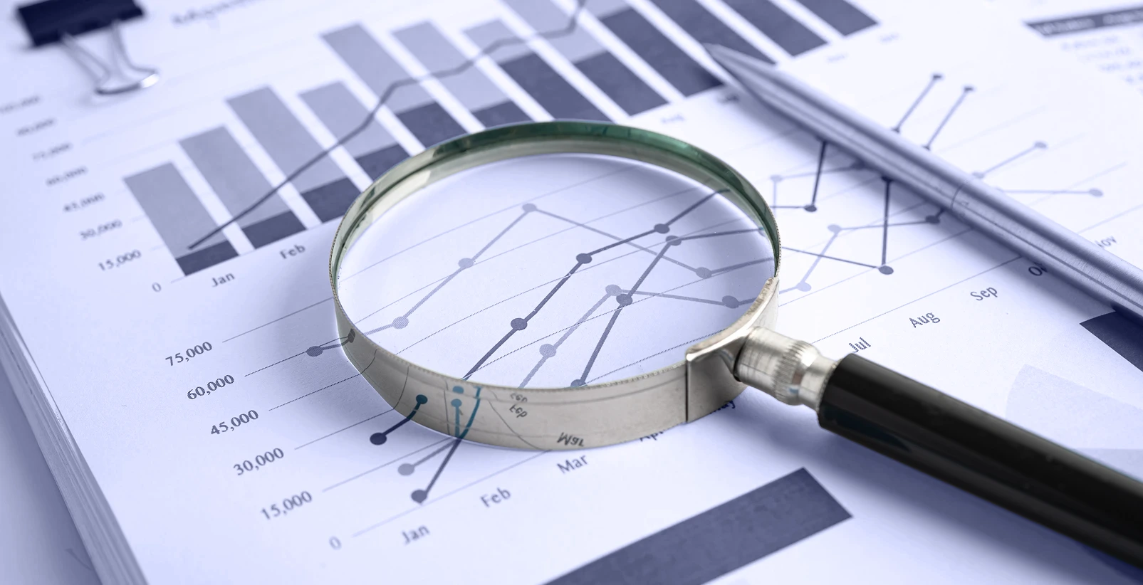 Magnifying glass above the paper report