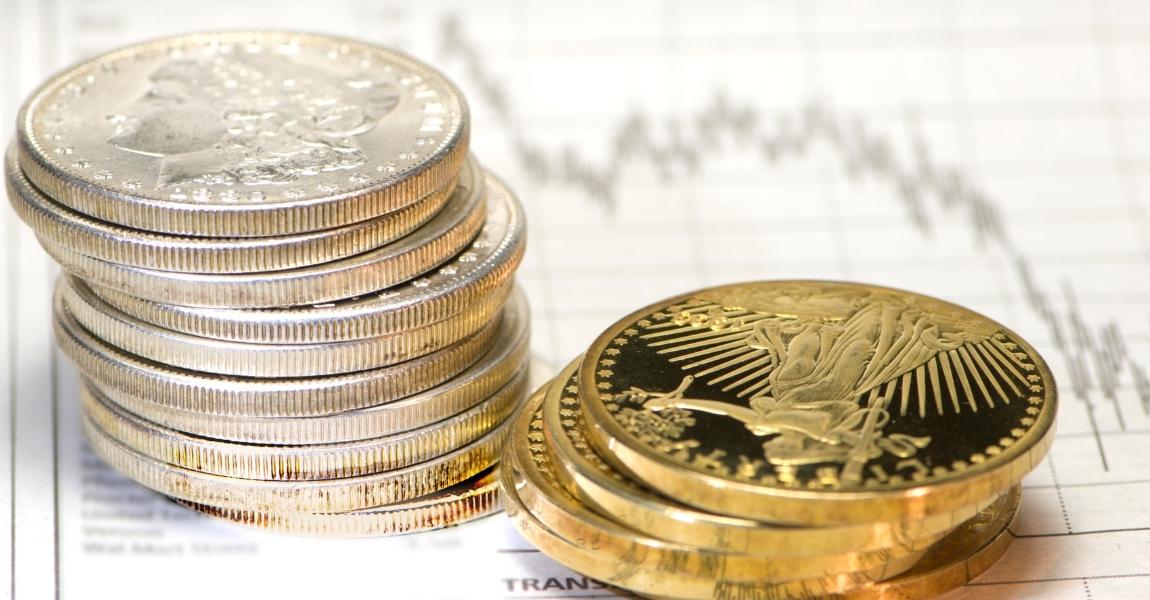 gold an silver coins on top of charts