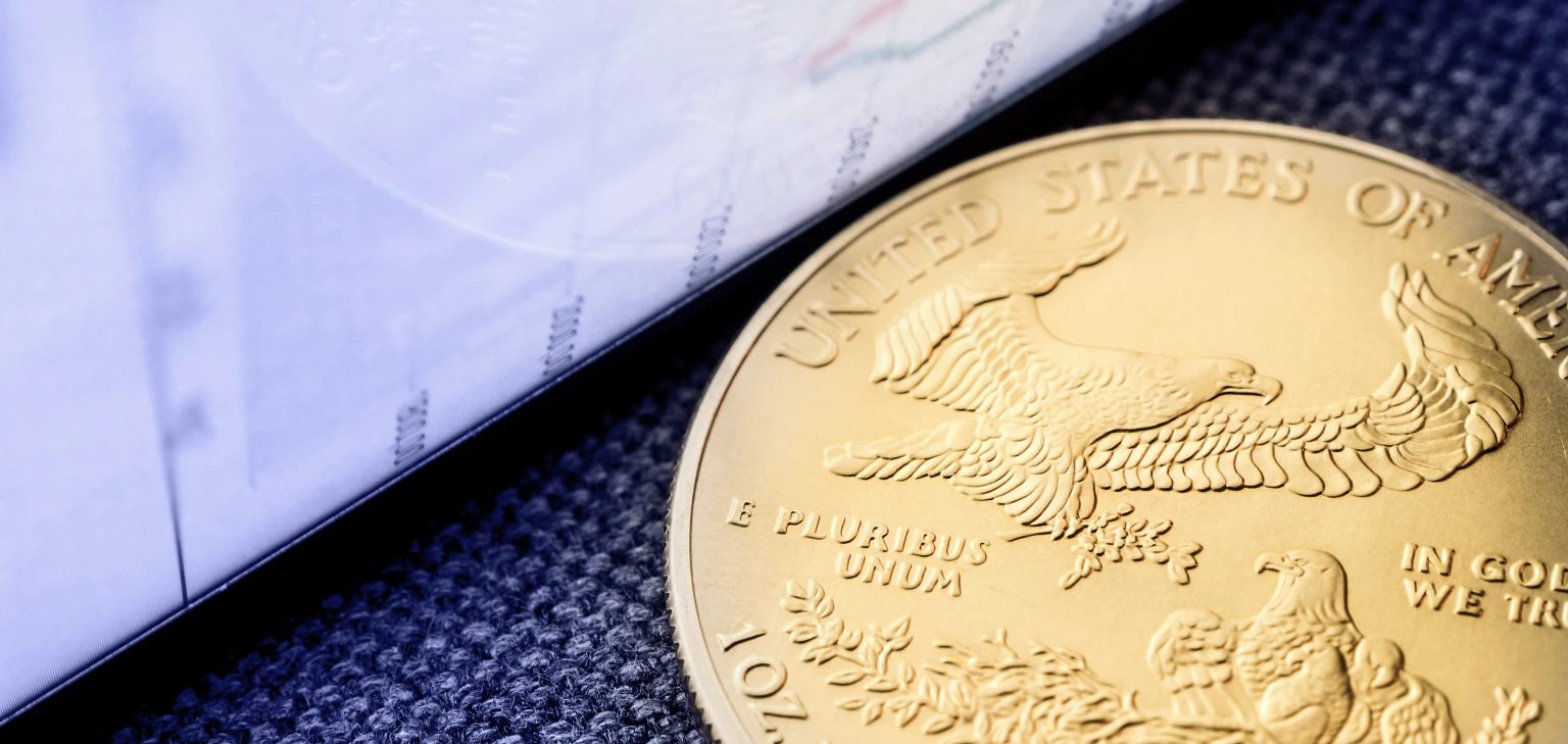 American gold coin beside of paper